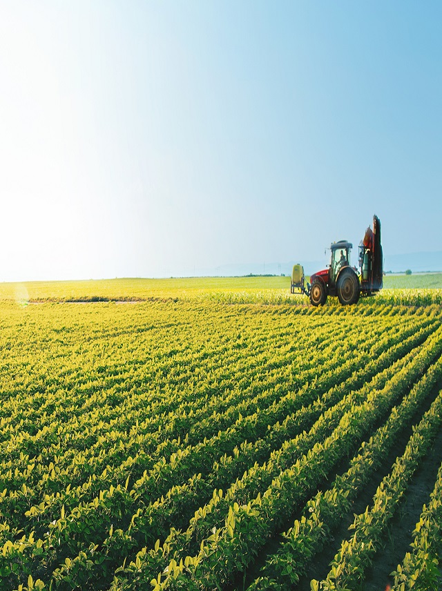 Agriculture - tractor in green farm field future of agribusiness